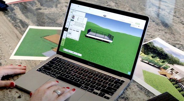 A person sitting at their laptop with Trex's Deck Designer tool being used on the screen.