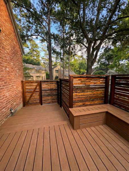 Trex composite deck with cedar privacy wall and built-in seating. Designed to create a private, functional outdoor environment.