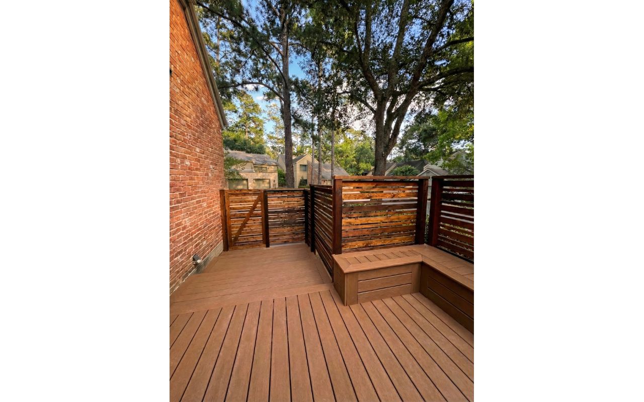 Trex composite deck with cedar privacy wall and built-in seating. Designed to create a private, functional outdoor environment.