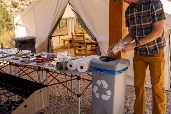 Man recycling plastic on a camping trip to be turned into Trex products. 