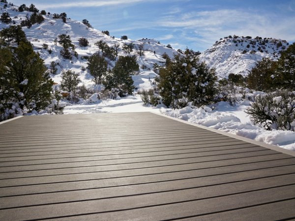 A platform made from Trex decking in the color Biscayne in a national park where there is fresh snowfall and hills with greenery littering the hills.