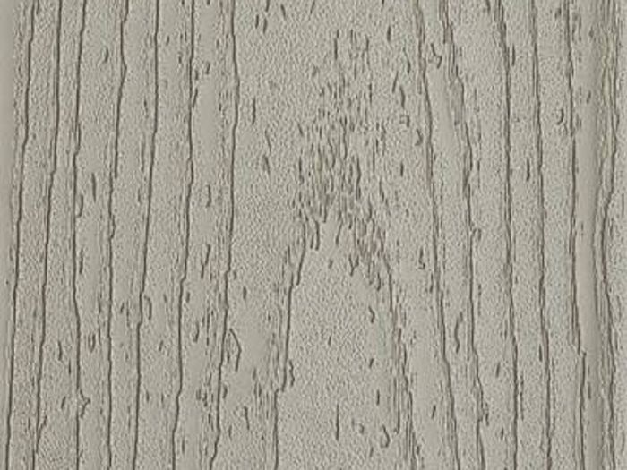 A close-up image of a textured surface featuring a light gray wood grain pattern. The visual highlights the natural lines and grooves typical of wood, with a subtle, neutral color palette. The image focuses on the organic texture and linear details, suitable for backgrounds or material references. No visible text, numbers, or identifiable brands are present.