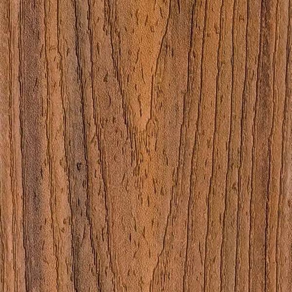 A detailed close-up of a natural wood surface, showcasing prominent brown grain patterns and subtle texture variations. The image highlights the organic lines and knots typical of wood, with warm earthy tones throughout. No visible text, numbers, or identifiable brands are present in the image.