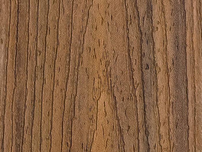 This image features a detailed close-up of a wooden surface, highlighting the natural grain and texture. The wood displays vertical lines and organic patterns in various shades of brown. The setting is neutral, focusing solely on the material's surface without any additional objects or text. The overall mood is warm and rustic, suitable for backgrounds or design inspiration.