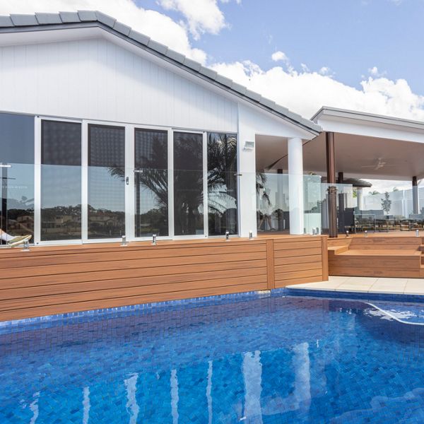 A Tiki Torch Trex deck next to a pool