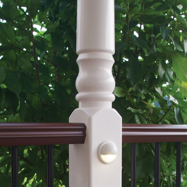 A white rail post with a white railing light.