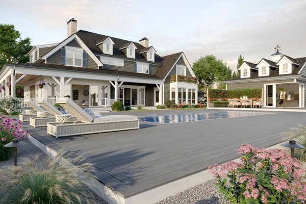 A home with Trex Transcend Lineage® color Island Mist Lineage® on a deck with a pool and pool furniture decorating the deck. 