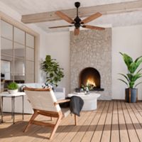 A stylish outdoor patio features a cozy stone fireplace as the focal point, surrounded by comfortable seating and lush green potted plants. The space is accented with wooden beams, a ceiling fan, and a neutral color palette, creating a serene and inviting atmosphere. Natural light floods the area through large windows and open arches, enhancing the modern yet relaxed setting. No visible text or numbers are present in the image.