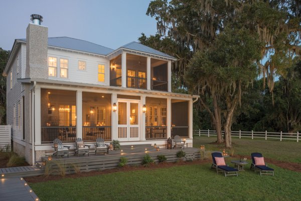 A house illuminated in the evening that is accented by Southern trees and Trex, whos deck has withstood storms, hurricanes, and other extreme weather conditions while looking beautiful.