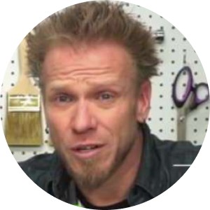 A workshop setting featuring a pegboard with various tools, including a paintbrush and scissors, hanging in an organized manner. The background suggests a creative or DIY workspace. The tools are clearly visible and neatly arranged.